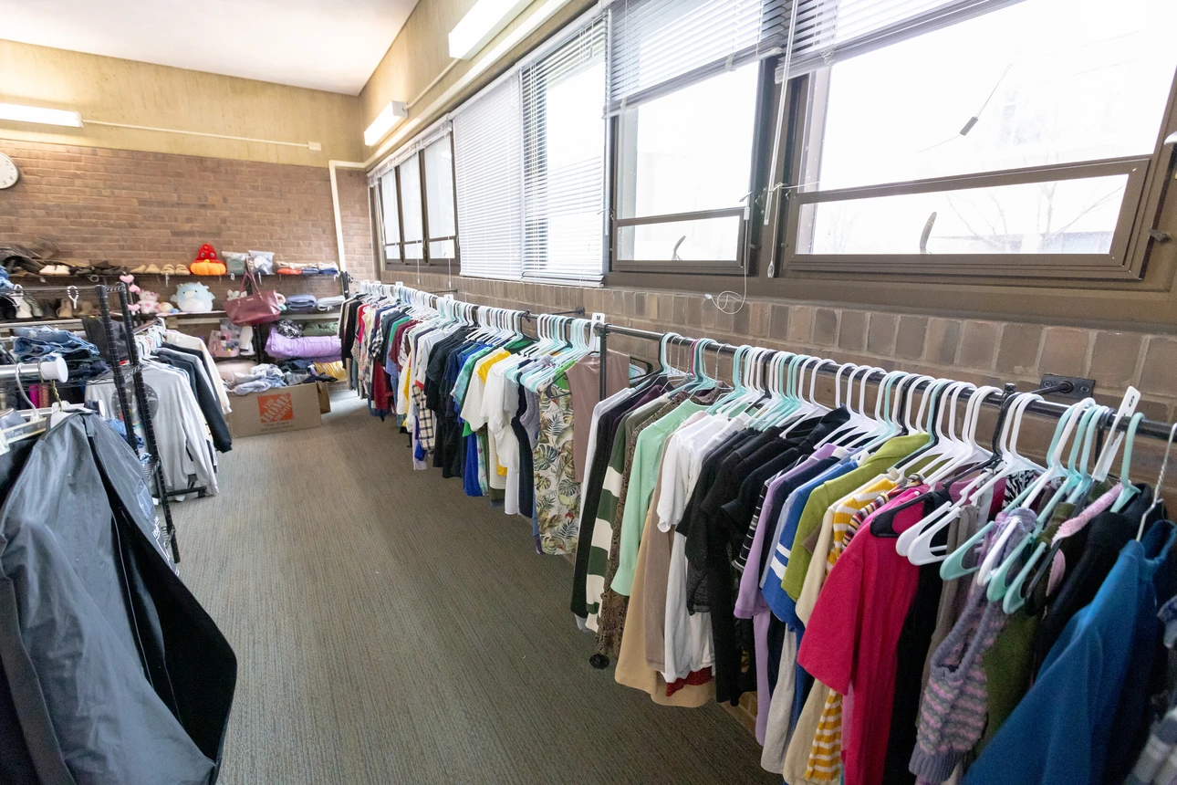 The Thrift Room photo of clothing along a wall with a window