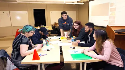 business students work together on a project inside a classroom