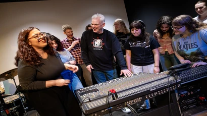 Fredonia student sin the music industry program cracking jokes at a mixing board