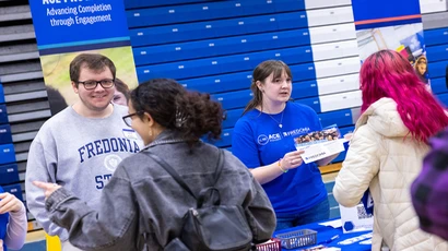 students talk to advisors at an open house table