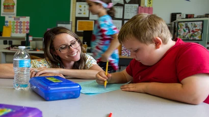 Fredonia student teacher working with a student in a classroom