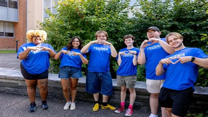 res life students making hearts with their hands, getting ready to welcome new students to campus