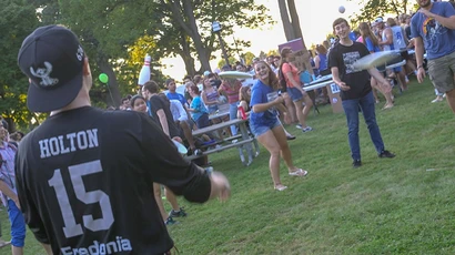 student play frisbee during Activities Night outside Steele Hall