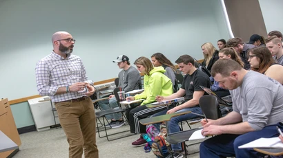 Dr. Mark Nickerson teaching finance class, in front of classroom full of students