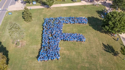 aerial photo of students forming the Fredonia "F" on the lawn