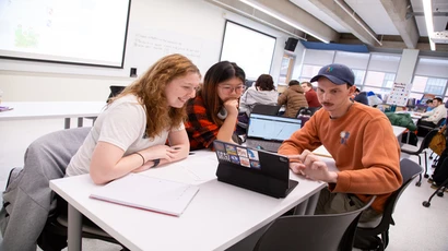 students in a classroom looking at a laptop
