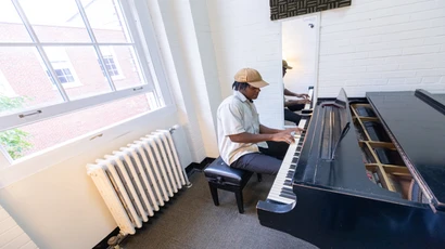 Student practicing piano in one of Fredonia's 100+ practice rooms  
