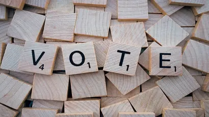 the word "vote" spelled out on tiles