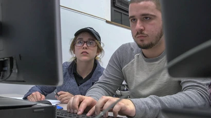 Two computer information science major students work on a computer in Fenton Hall. Computer information systems degree, degree in computer information systems, cis degree.