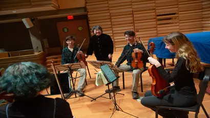 School of Music students in the string quartet practice in a recital hall 