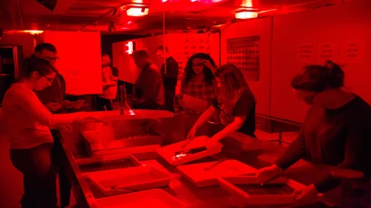 Students experiment with photograms and developing prints in the Igoe Hall darkroom. degree in photography, photography degree, major in photography.
