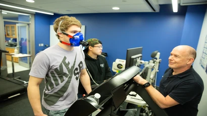 A student walks on a treadmill while wearing gear monitoring his breathing. Degree in exercise science, exercise science degree, exercise science jobs, major in exercise science