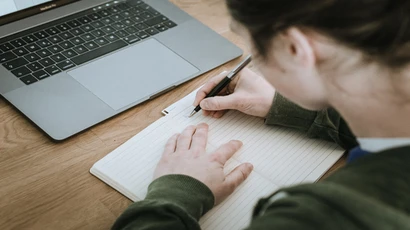 graduate bilingual education extension major, graduate bilingual education extension degree, graduate bilingual education extension majors in new york, person writing in a notebook with laptop computer open