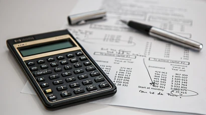 A photo of a calculator sitting on top of paper indicating a financial spreadsheet, finance degree, degree in finance, finance major,  degrees finance.