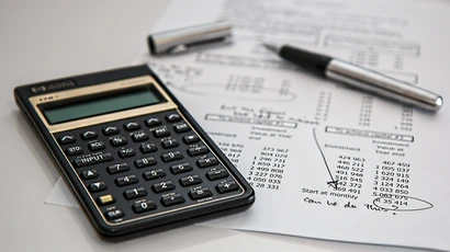 A photo of a calculator sitting on top of paper indicating a financial spreadsheet, finance degree, degree in finance, finance major, degrees finance.
