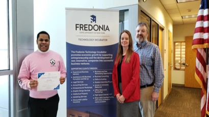 SBC Fall 2022 Winner posing with certificate next to director Chuck Cornell and project coordinator Lauri Gawronski