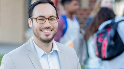 graduate educational leadership program, education leadership, graduate educational leadership colleges in new york, graduate educational leadership degree, school administrator poses outside local high school