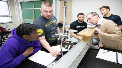 Physics professor Michael Dunham, with students in a lab.