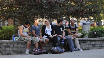 Students sitting over a bench