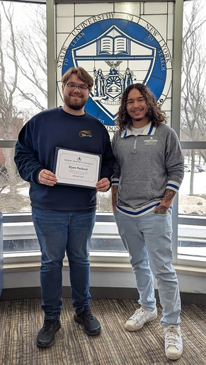 Ryan Packard holding certificate and Eisenhower Hall Residence Director Christian Taber.