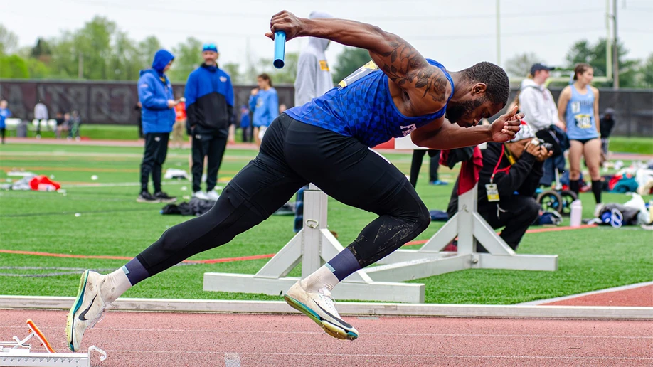 runner with baton in mid-stride