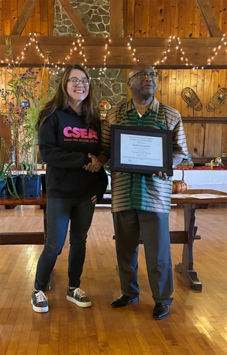 Stephanie Teachman accepts the 2025 Poummit Secretarial Award from President Dr. Stephen H. Kolison Jr. 