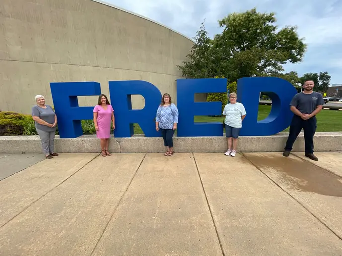 photo of award winners in front of FRED sculpture