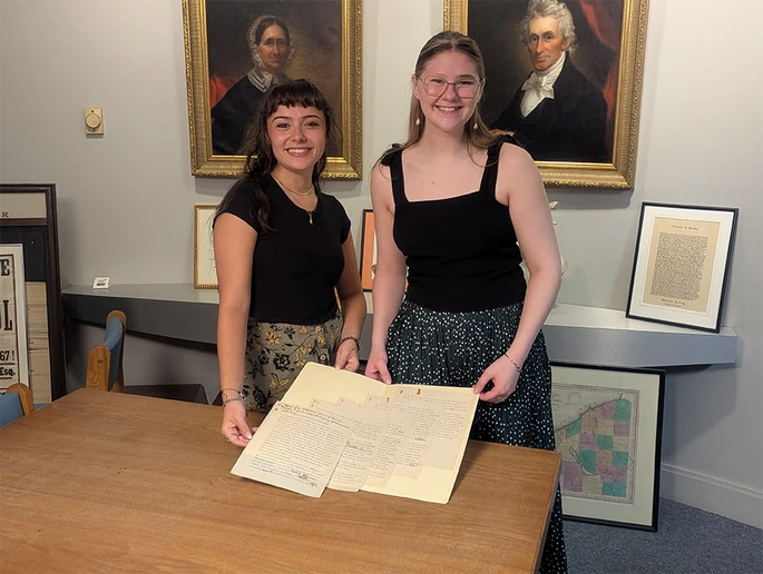 Jasmine J. Johnson (left) and Rebekah Gerace display the original Stefan Zweig document that advocated for a library to retain books that were banned in Germany under National Socialism.
