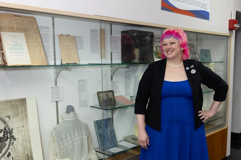 Amanda Shepp, coordinator of Special Collections and Archives in Reed Library, stands in front of the bicentennial exhibit set up in Fenton Hall