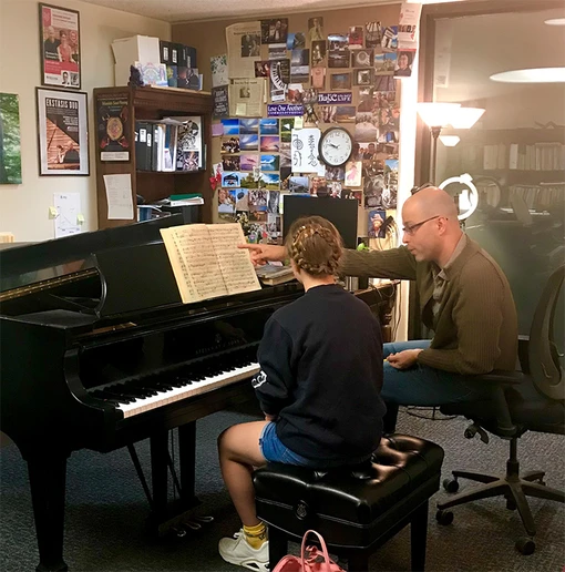 Dr. Eliran Avni works with a student during a Piano Camp.