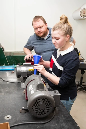 Mia Enders, a junior Geology major from Bath, NY, with Dr. Thomas Hegna, operates equipment that pulverizes and grinds rocks for analysis.