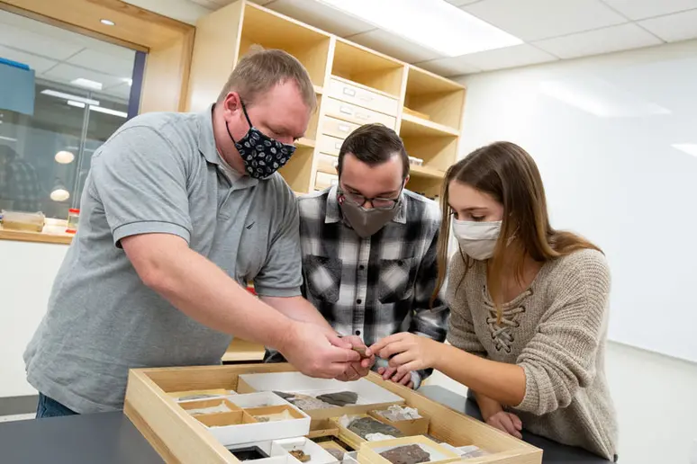 students with professor in geology lab