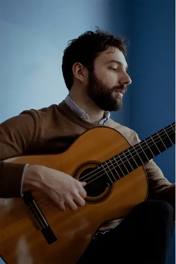 SUNY Fredonia alumnus Anthony LaLena playing guitar