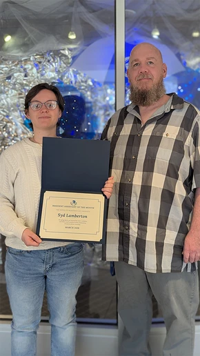 Syd Lamberton accepts the award for Resident Assistant of the Month from Residence Director of University Commons and Gregory Hall Jacob Steinhoff.