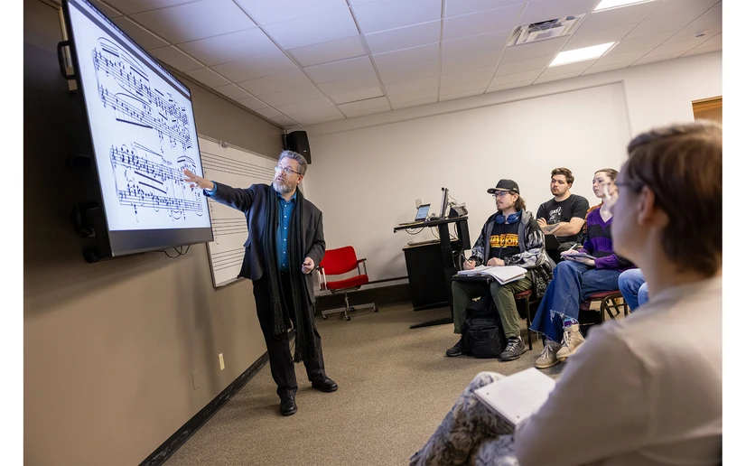 Dr. Rob Deemer at the screen pointing out music to students