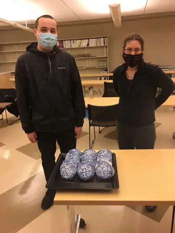 student and faculty member with tray of cookies