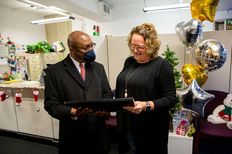 Kellie Sacilowski admires the Poummit Secretarial Award presented by President Stephen H. Kolison Jr.