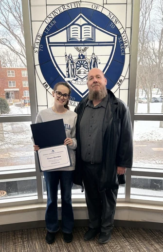 Grace Riodan, with her RA of the Month certificate, Residence Director of University Commons and Gregory Hall Jacob Steinhoff. 