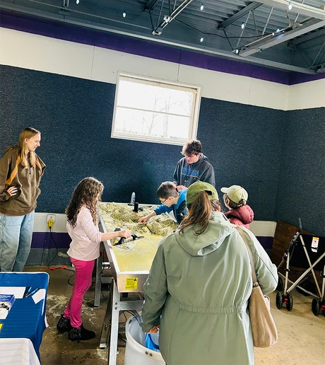 SUNY Fredonia students lead children through exploration of the stream table at the Gem and Mineral Show.