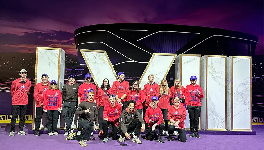 The SUNY Fredonia contingent gathering in front of a large Super bowl LVIII sign include (front row, from left): Zach Helms, Matt Volz, Davon Kubasik, Zach Roache, Dr. Kerry Fischer; (back row): Mason Neale, Mark Hall, Dr. Linda Hall, Ian Summerson, Joshua Santacroce, Rachel Bayer, Parker Gurnett, Brynn Morseon, Noah Richner, Kayla Welsh, Madison Esmond and Alex Smith.
