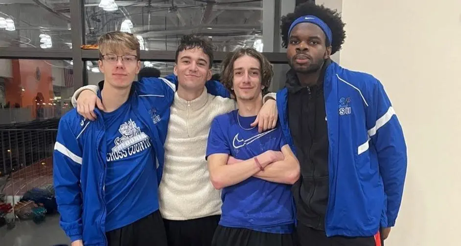 four track and field athletes standing together