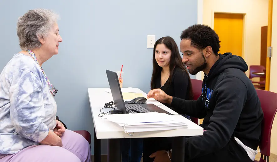 SUNY Fredonia junior Accounting students David Jordan, of Philadelphia, PA, and Shon Thompson, Gowanda, NY, review the tax return they have prepared for Fredonia, NY, resident Helen Burt.