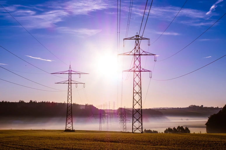 Energy transmission lines with bright sunlight behind