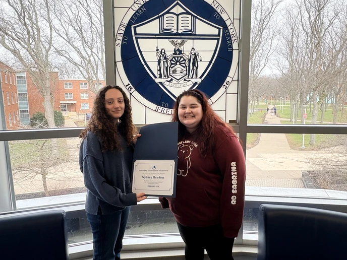 Sydney Hawkins holding certificate and Kasling Hall Director Sabrina Sosa.