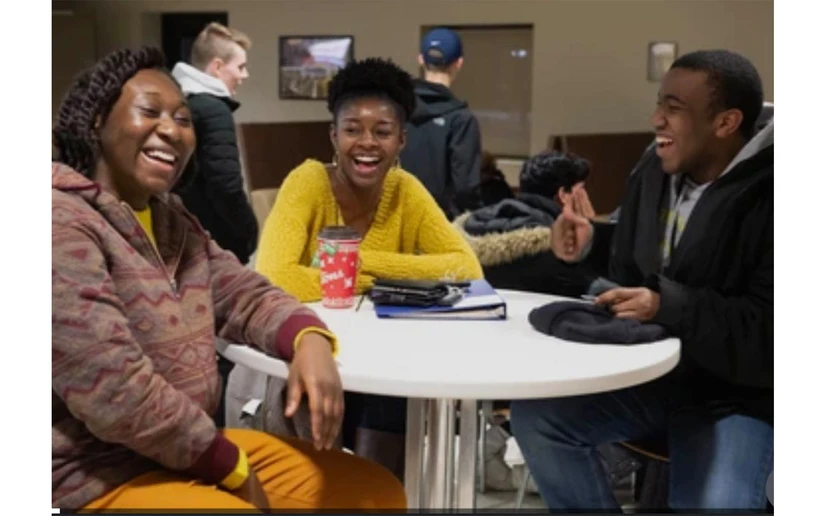 students sitting around a table laughing