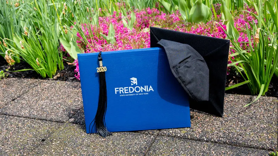photo of diploma cover and mortarboard