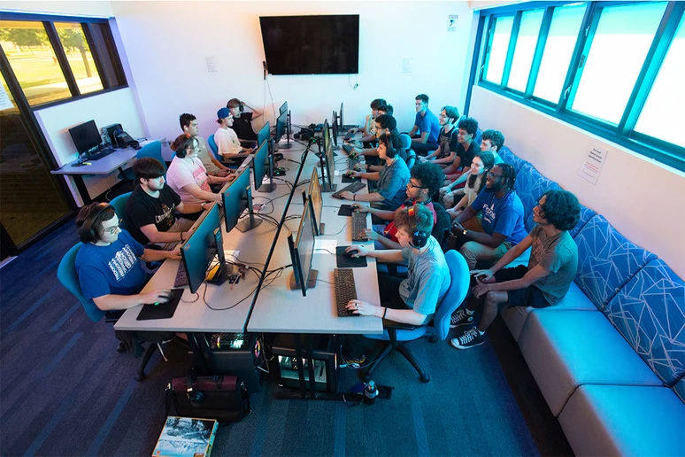 Members of the eSports team gather in the eSports Lounge in Schulz Hall, either playing games and others following the swift action.