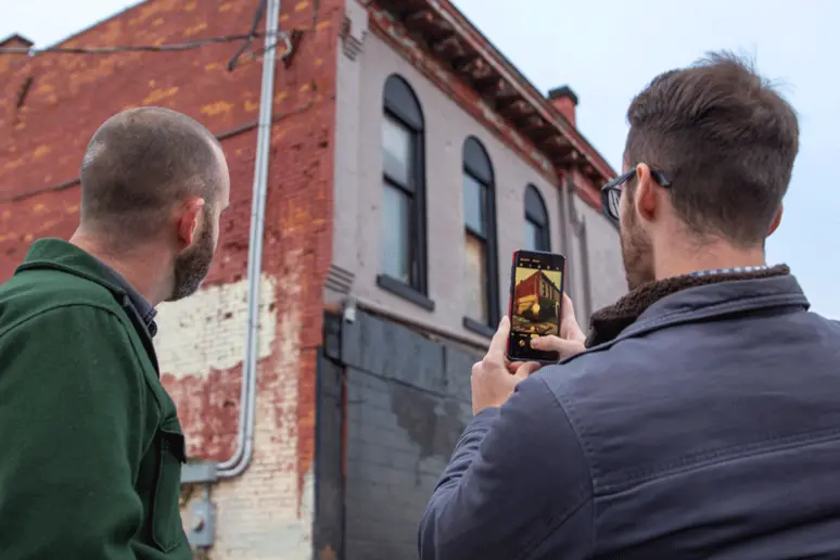 student takes a photo of buildings
