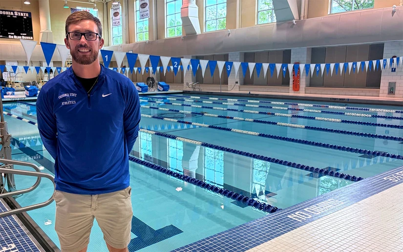 Portrait of Ryan Kreuser, head coach of Fredonia State swimming and diving beside pool