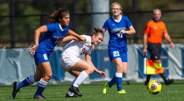 Sydney Tanner tangles with a Potsdam player while Karen Johnson looks on